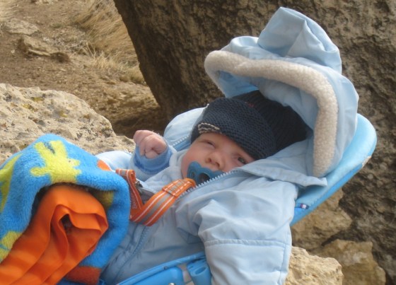 The orange lanyard shown here is girth-hitched to the blue pacifier (on the right end), and then clips to baby's outfit (on the left end).