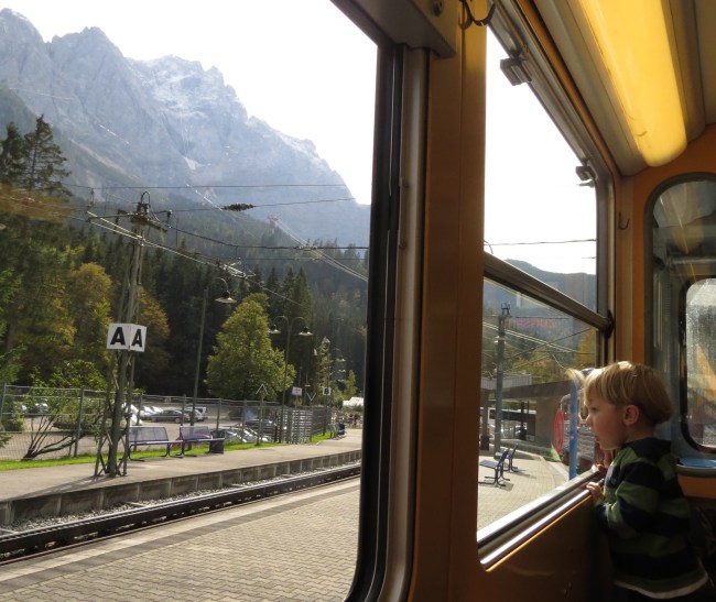 Logan on the cog train, with the snow-plastered Zugspitze looming out the window.