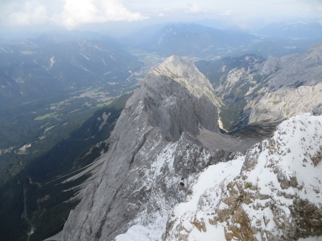The view down the north face. Garmisch is at the top, center. The lower cable car station is visible on the far left (follow the line formed by the two red and white cable towers), and a red gondola is visible at lower center.