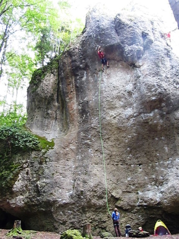 Reaching for the jug at the lip of the roof.