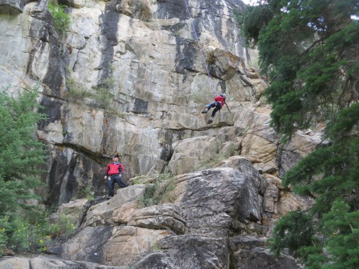 Logan swinging from the top of the classic 5.11 Thug Route.